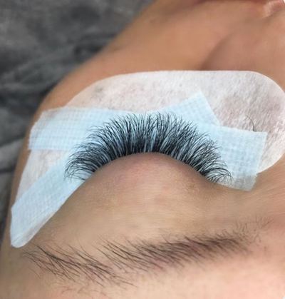 Volume lash set seen side-on over a blue tape and eye pad